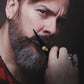 man cutting moustache with black and gold scissors